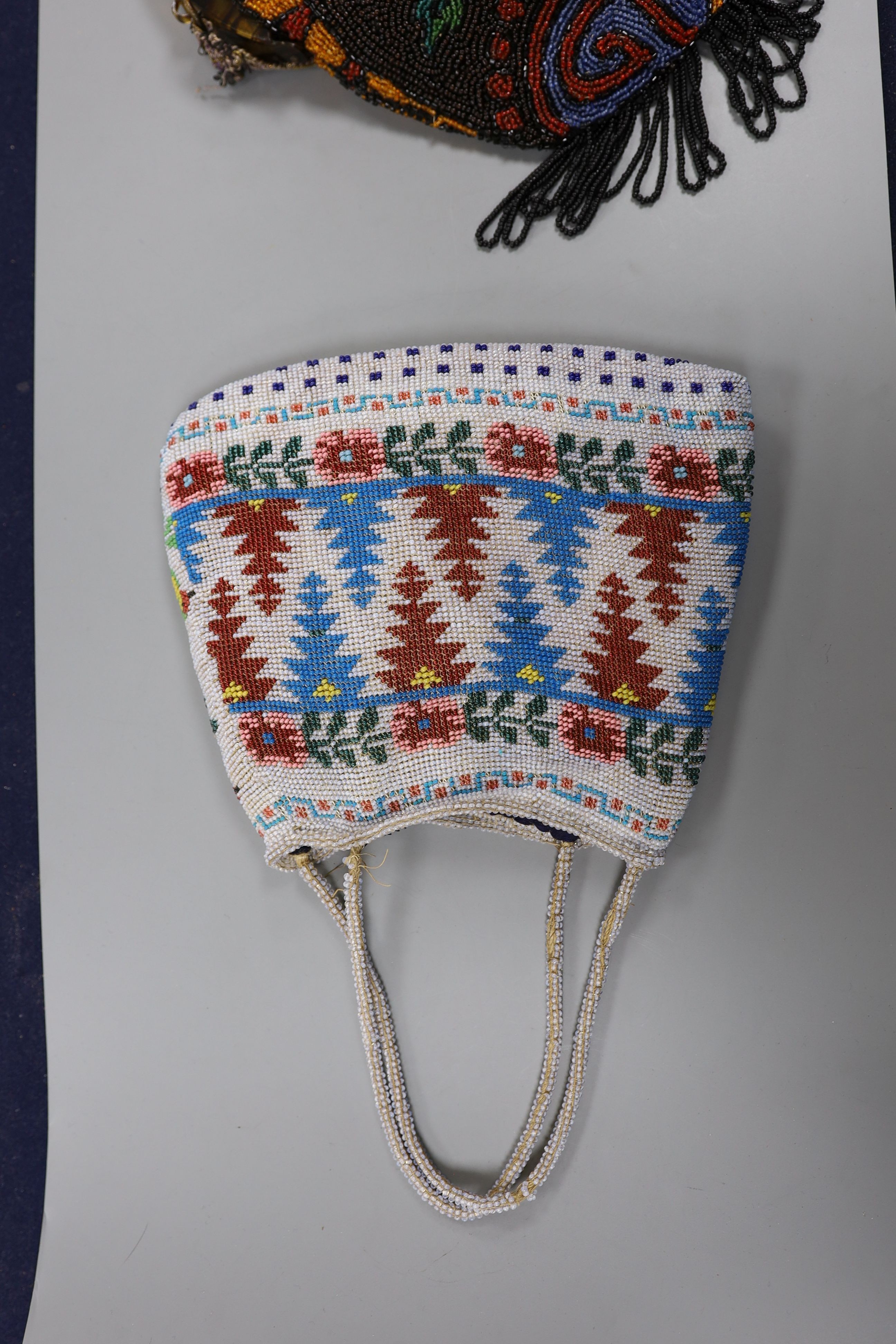 A fine needlework petit point evening bag, a 19th century bible bag, an early 20th century beaded bag and a 1930's beaded bag